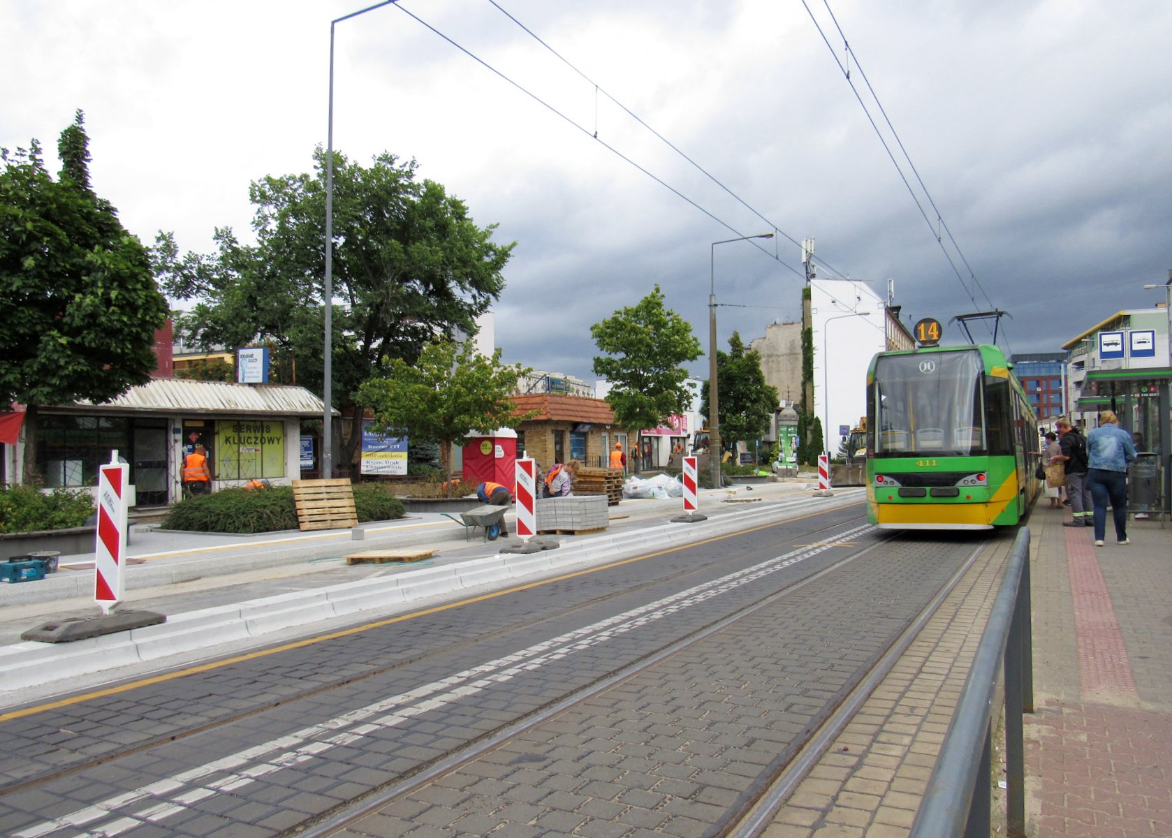 Dwa przystanki tramwajowe. Przy jednym stoi tramwaj, drugi przerabiany jest na wiedeński, widać płyty i słupki ostrzegające - grafika artykułu