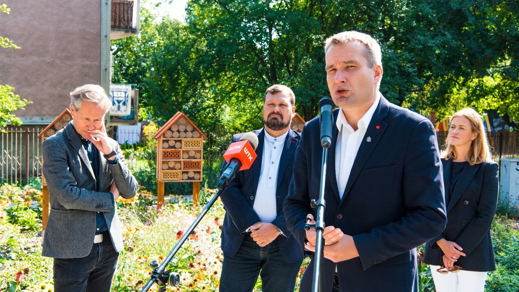 Galeria zdjęć przedstawia konferencję prasową na skwerze oraz sam skwer z zielenią i domkami dla owadów.