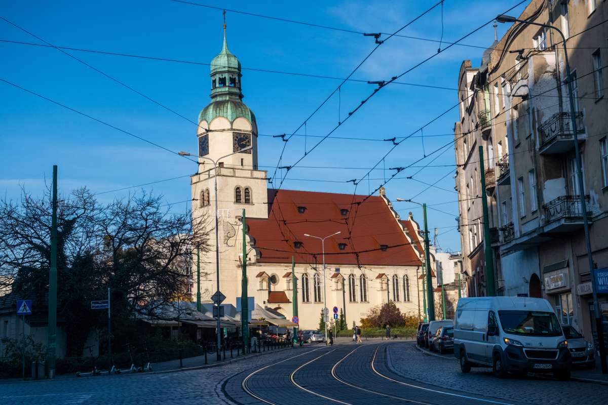 Zdjęcie przedstawia budynki i tory tramwajowe. - grafika artykułu