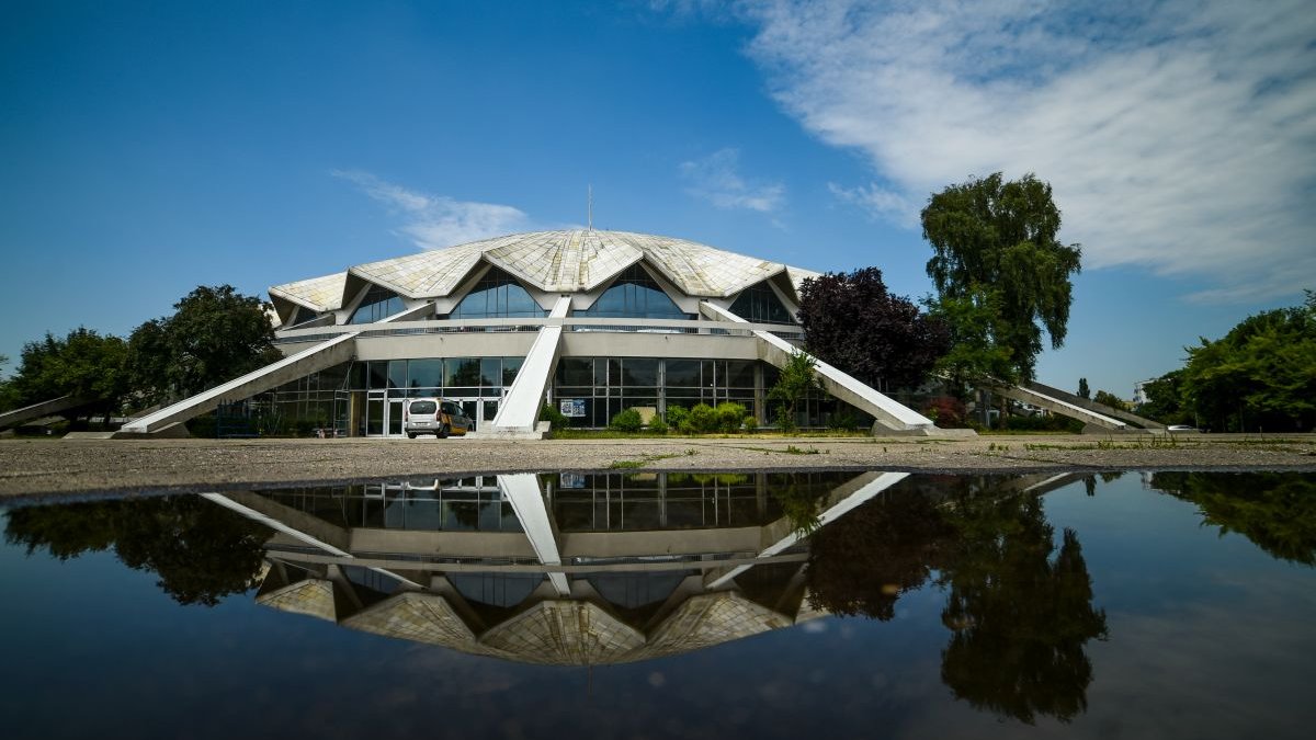 Zdjęcie przedstawia budynek Areny. Na dole fotografii widać obiekt odbijający się w wodzie.