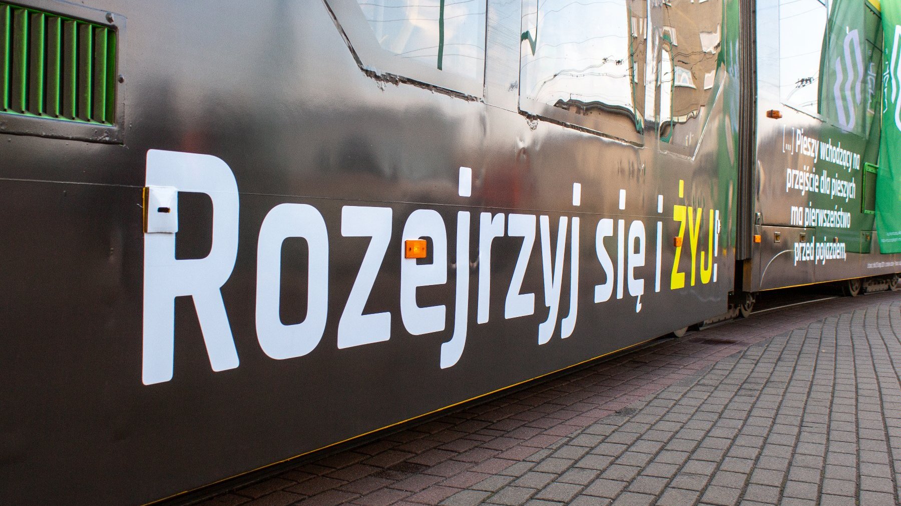 Tramwaj z napisem "Rozejrzyj się i żyj"