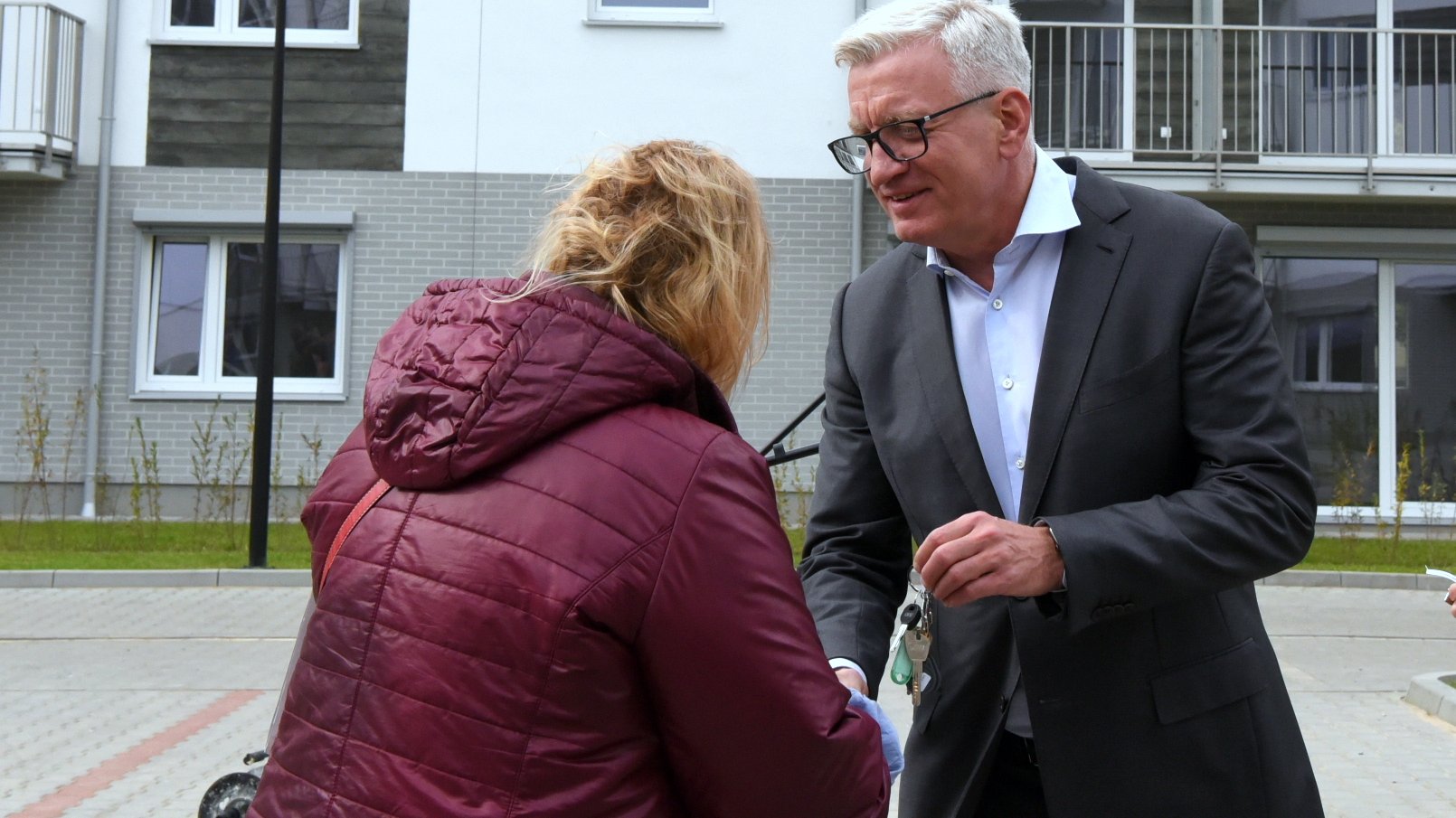 Na zdjęciu Jacek Jaśkowiak, prezydent Poznania, przekazuje klucze młodej kobiecie