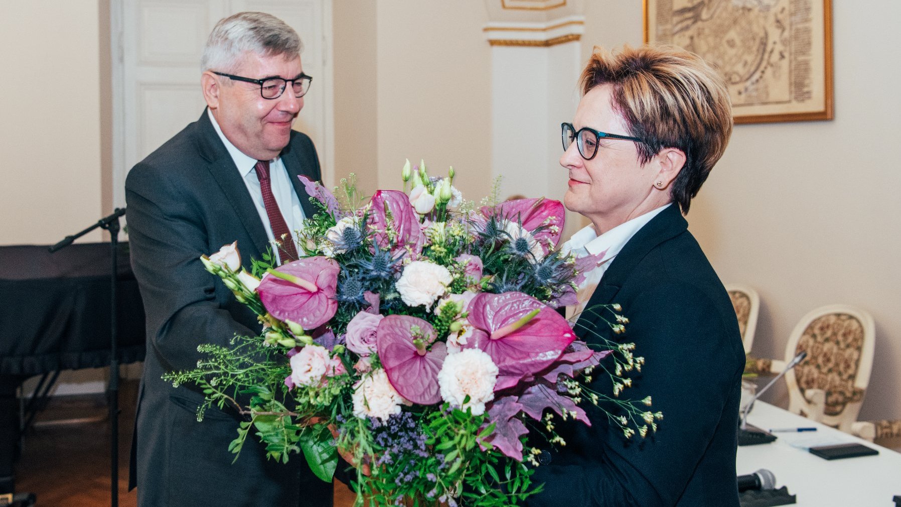 Grzegorz Ganowicz, przewodniczący rady miasta, wręcza bukiet Barbarze Sajnaj