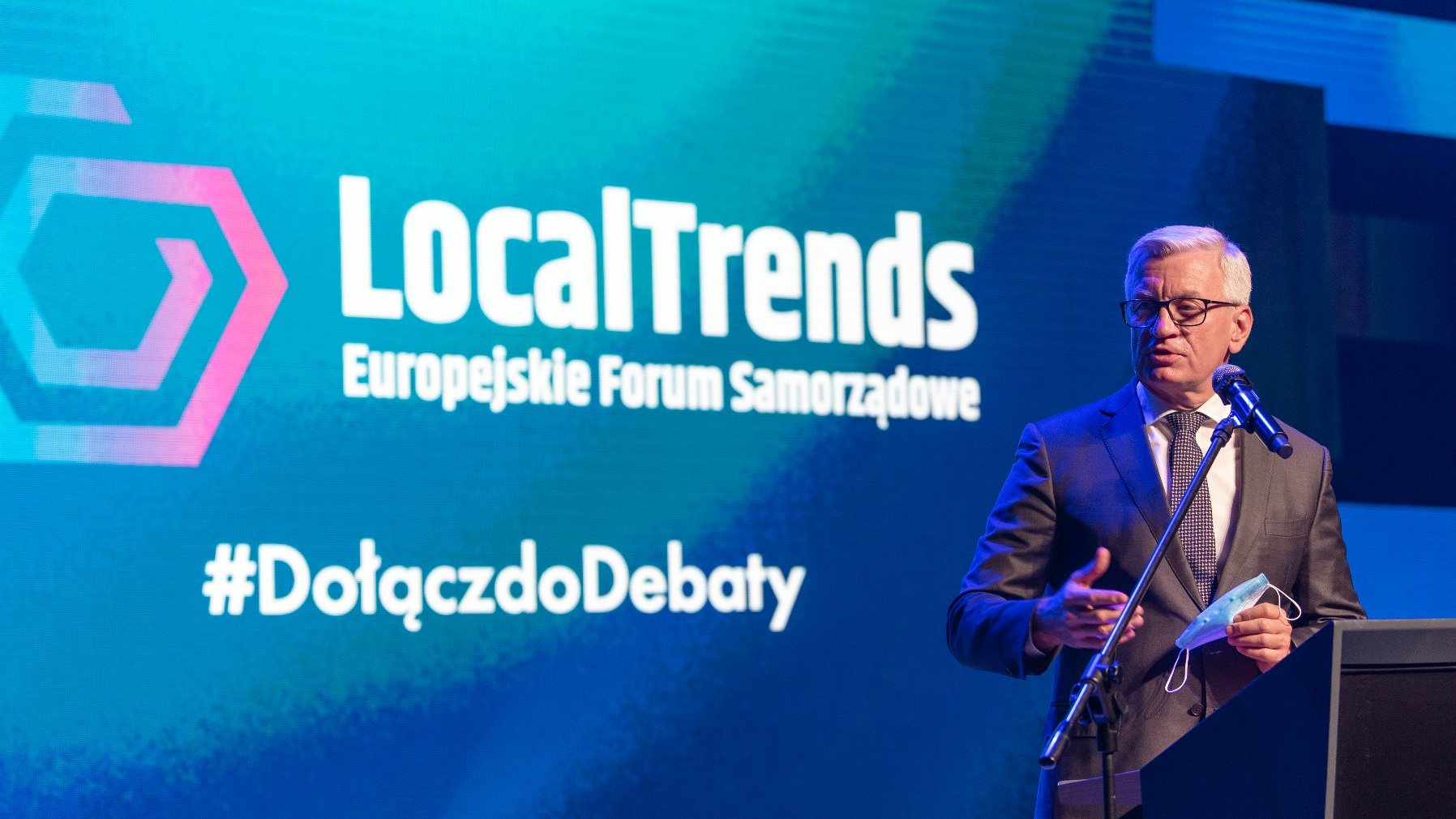 Jacek Jaśkowiak, prezydent Poznania, stoi przy mównicy, za nim ekran z napisem: Local Trends, Europejskie Forum Samorządowe