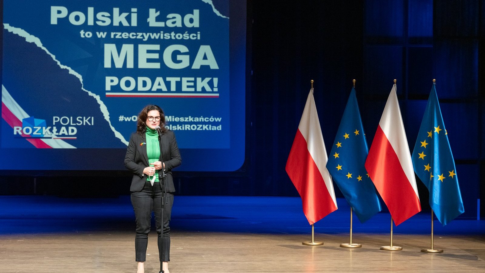 Na zdjęciu Aleksandra Dulkiewicz, prezydent Gdańska, na scenie, za nią plansza z napisem: Polski Ład to w rzeczywistości mega podatek