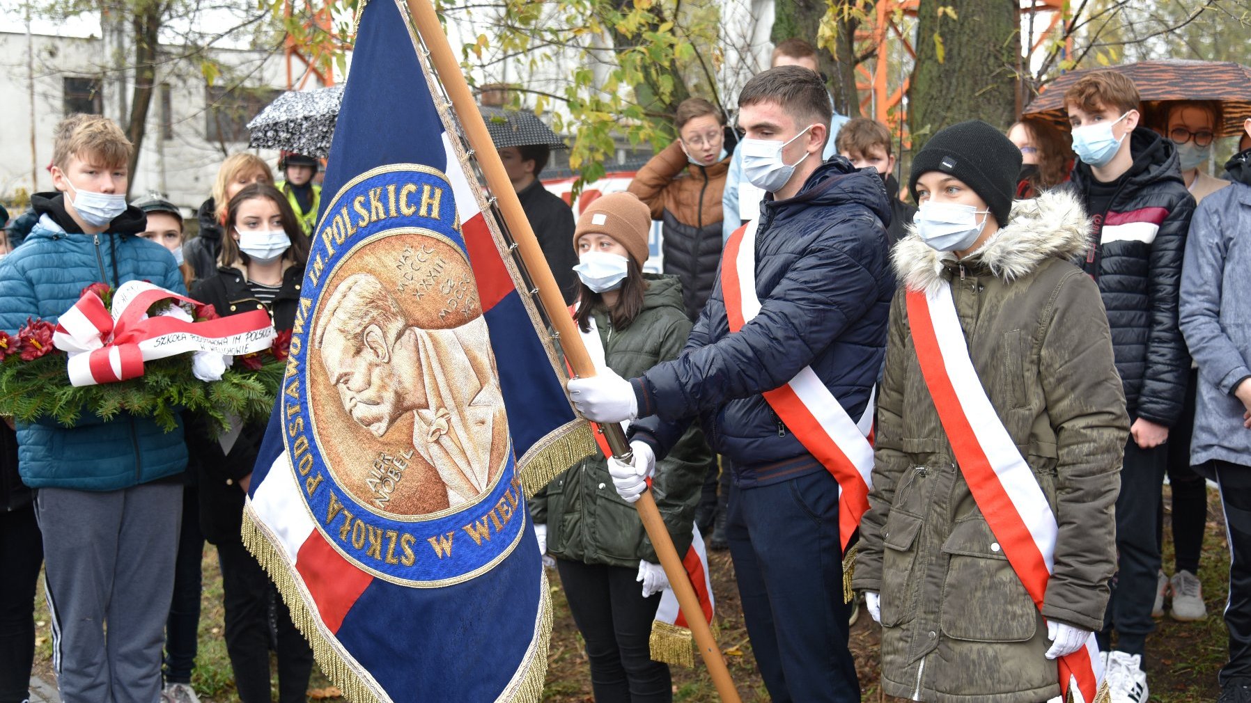 Zdjęcie przedstawia młodzież ze sztandarami.