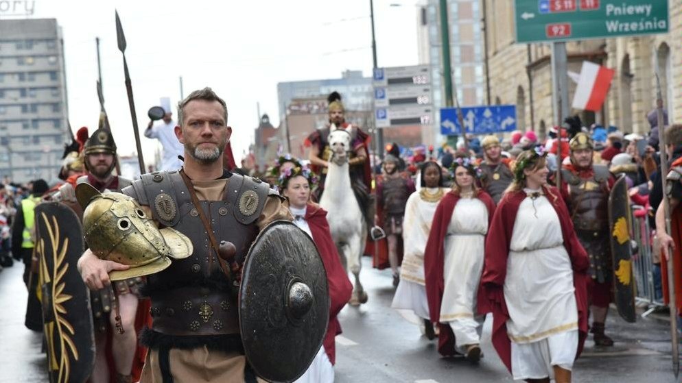 Zdjęcie przedstawia korowód po ul. Św. Marcin. Widać na nim wielu przebranych ludzi.