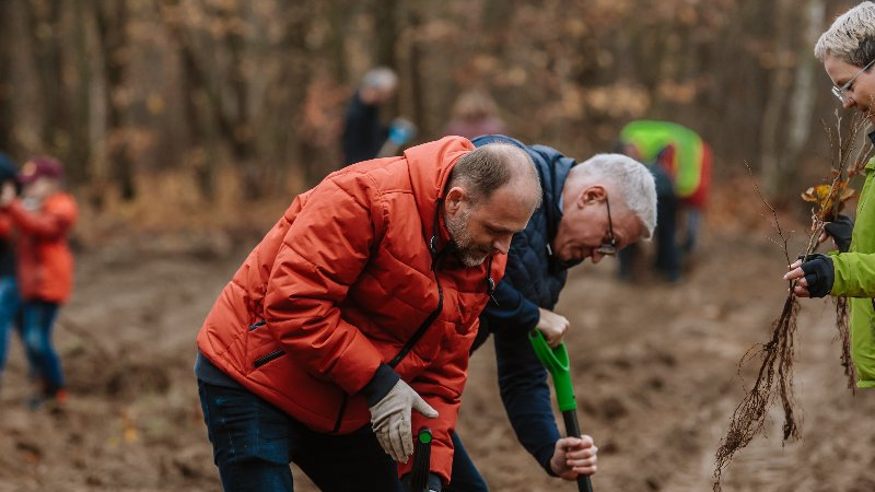 Zdjęcie przedstawia prezydenta i radnych osiedlowych sadzących drzewa.