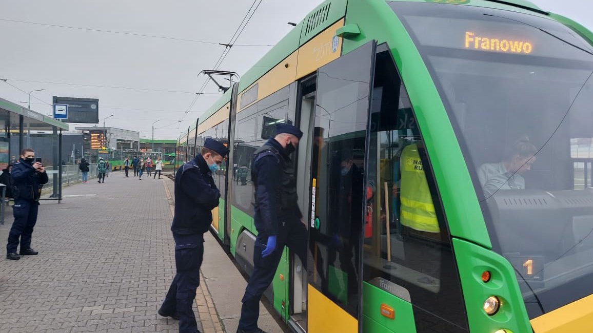 Na zdjęciu dwóch policjantów wchodzących do tramwaju linii 18