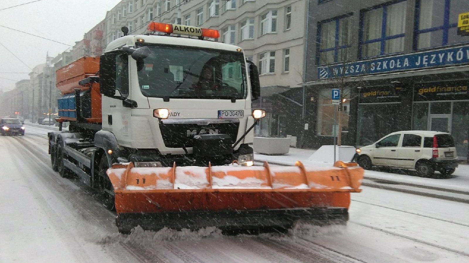 Pługopiaskarka odgarniająca śnieg z ulicy