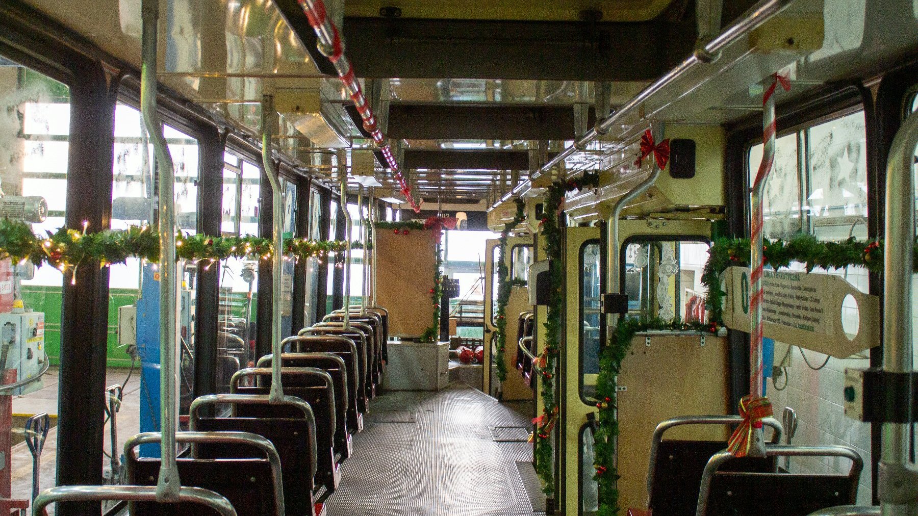 Zdjęcie przedstawia wnętrze tramwaju ozdobione świątecznymi ozdobami.