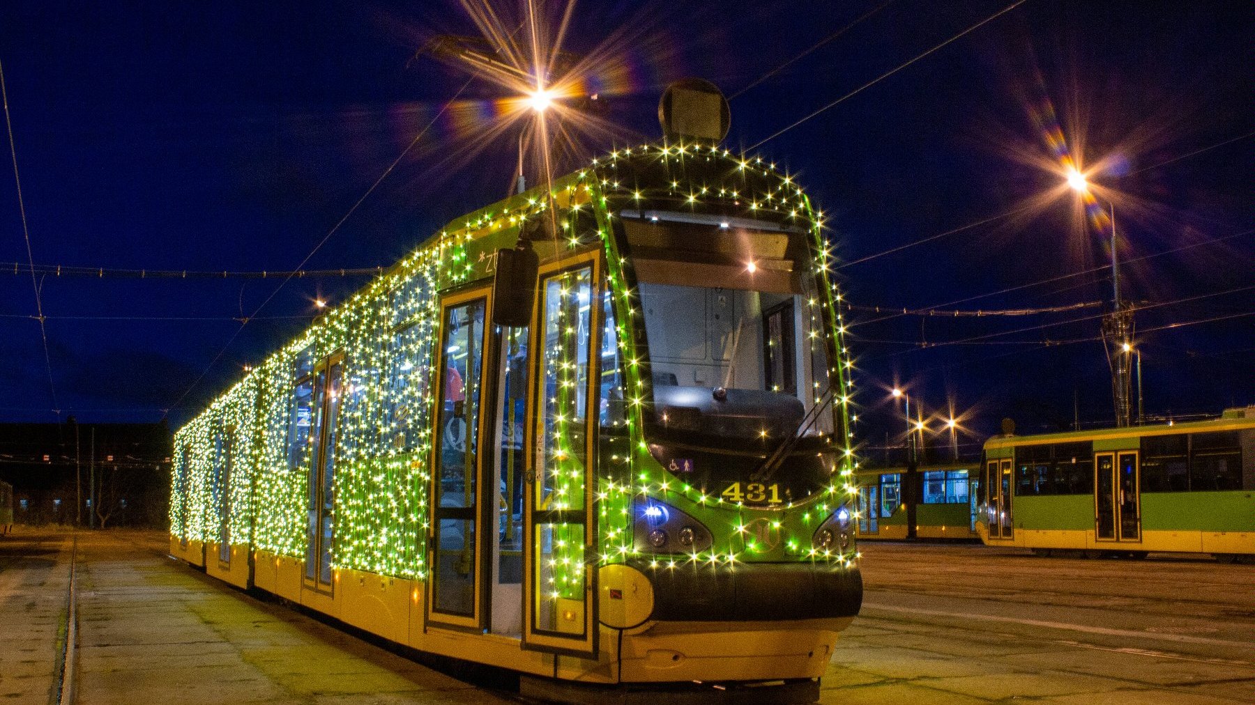 Zdjęcie przedstawia tramwaj ozdobiony świecącymi lampkami.