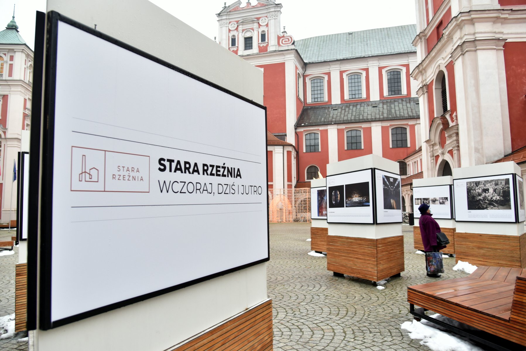 Galeria zdjęć przedstawia wystawę fotografii na dziedzińcu urzędu miasta przy pl. Kolegiackim. - grafika artykułu