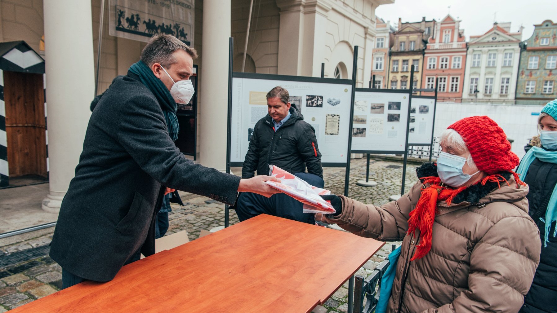 Galeria zdjęć przedstawia akcję rozdawania flag powstańczych poznaniakom na Starym Rynku.