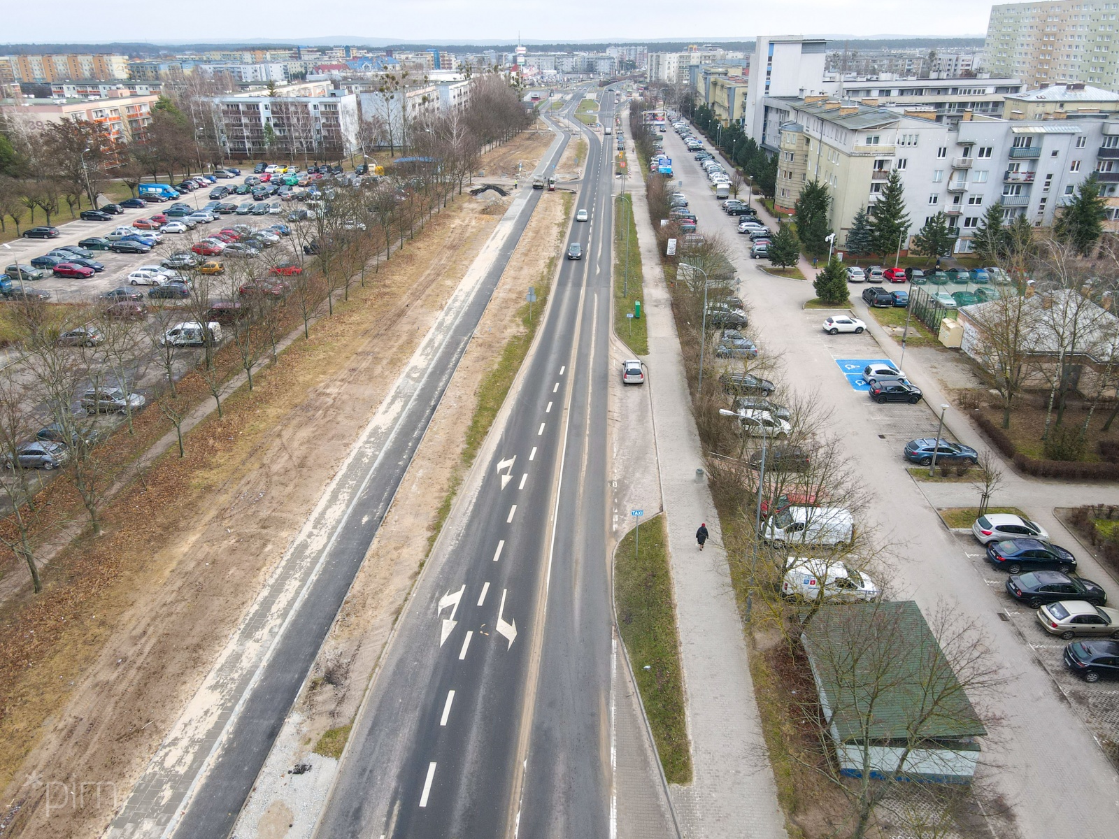 Na zdjęciu droga rowerowa widziana z lotu ptaka, po prawej bloki, po lewej parking - grafika artykułu