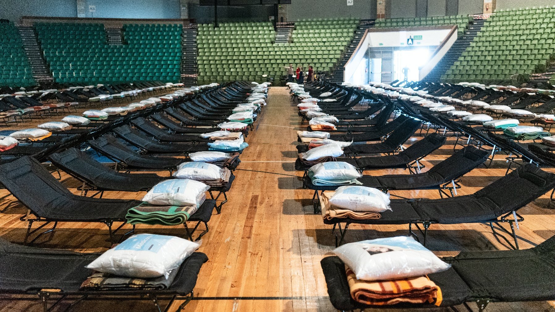 Wnętrze hali Arena. Na środki obiektu widać setki łóżek polowych.