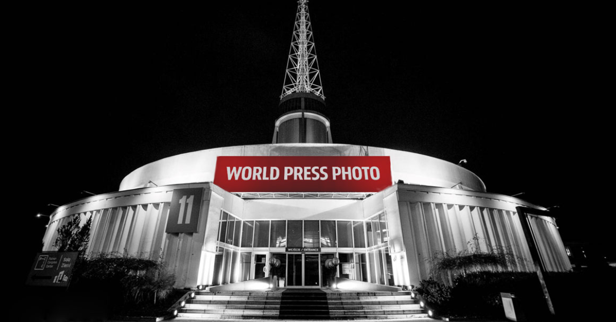 Grafika przedstawia zdjęcie budynku Iglicy MTP z napisem "World Press Foto". Fotografia jest czarno-biała, kolorowy jest tylko napis. - grafika artykułu