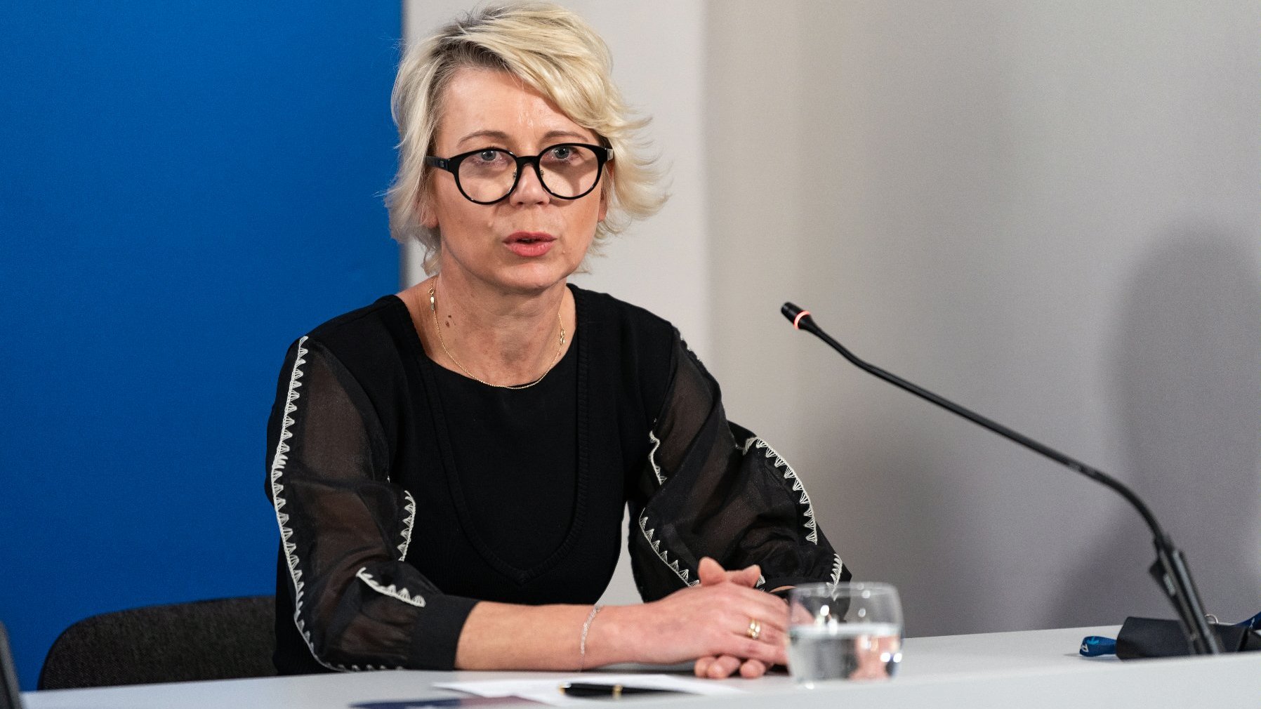 Na zdjęciu Iwona Matuszczak-Szulc za stołem konferencyjnym, w tle granatowa ścianka