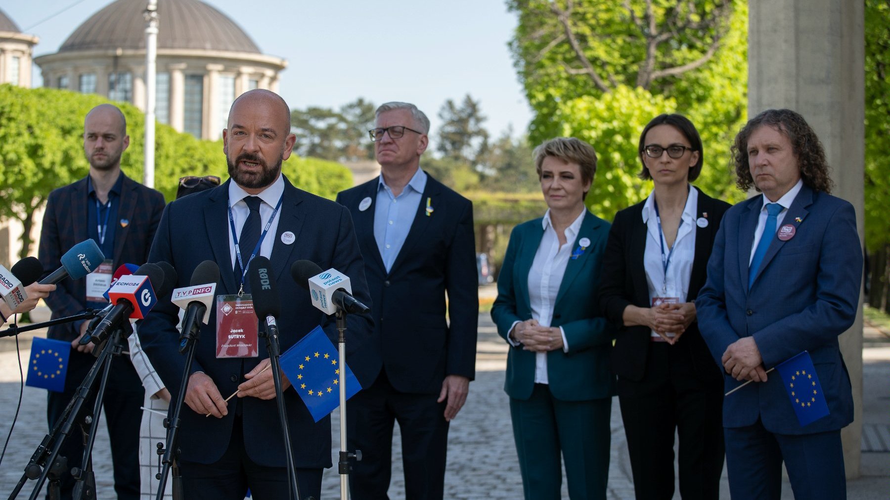 Zdjęcie przedstawia uczestników konferencji prasowej. Prezydent Wrocławia stoi przed mikrofonem.