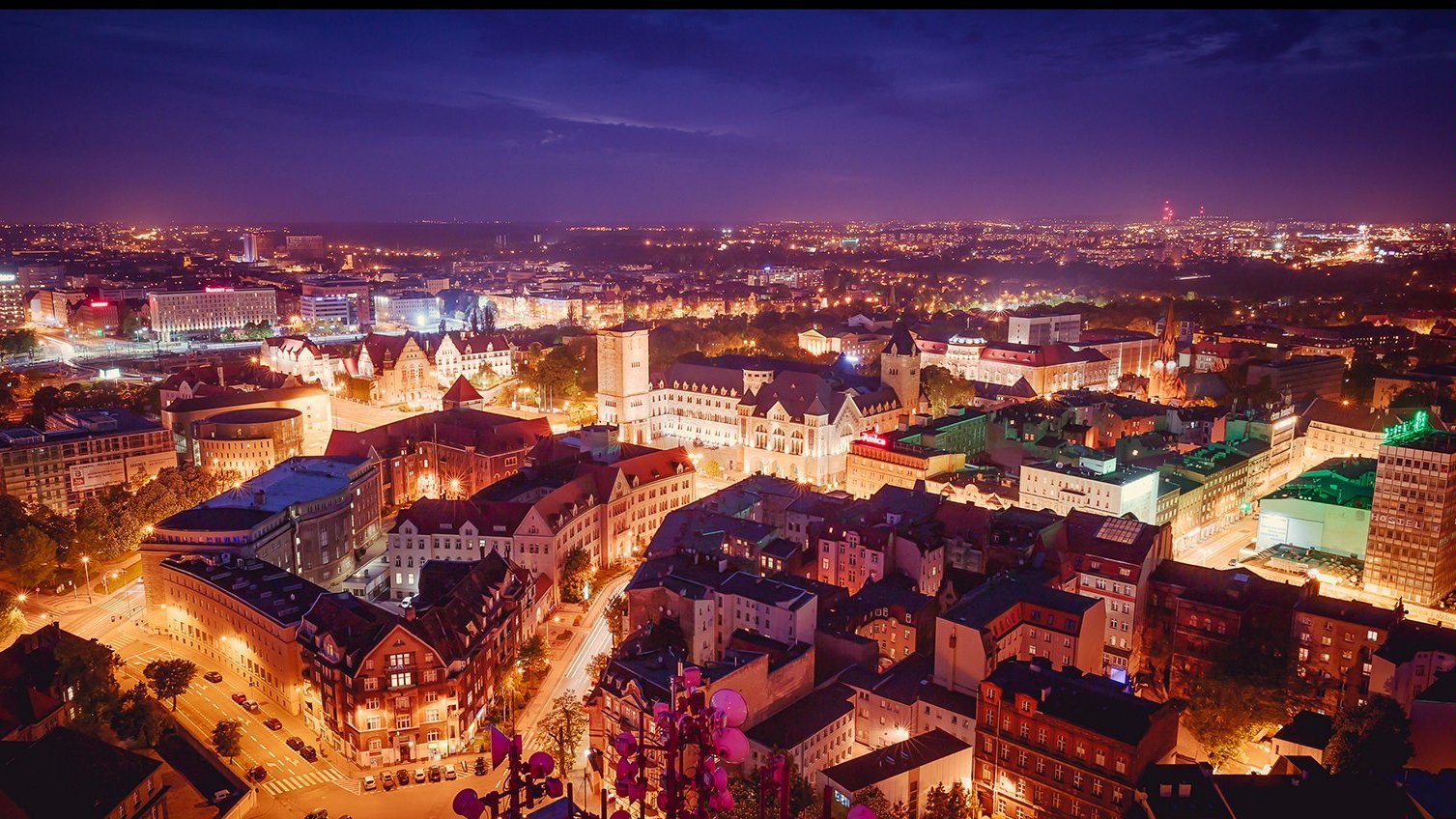 Na zdjęciu panorama Poznania po zmroku, w centrum zabudowa śródmiejska widziana z lotu ptaka