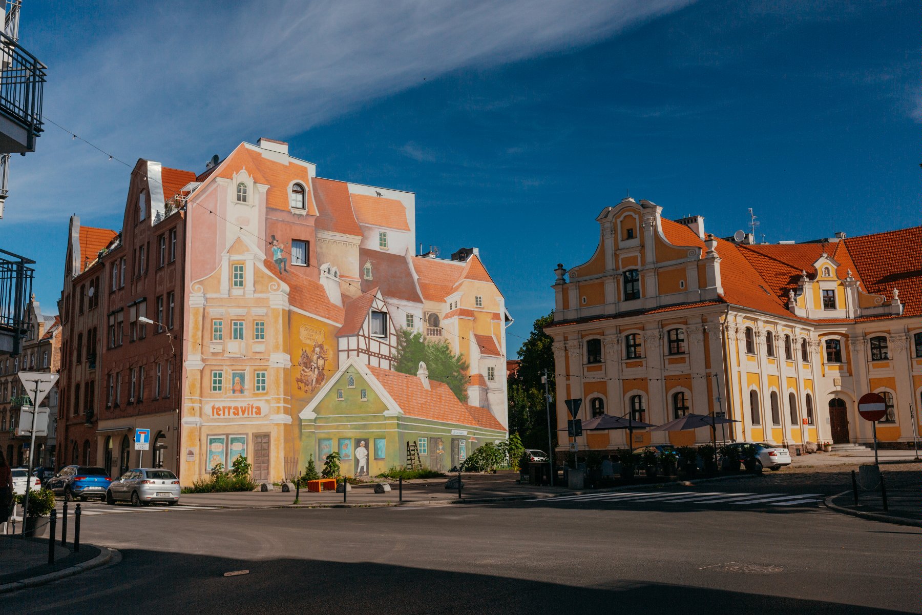 Zdjęcie przedstawia plac przed charakterystycznym śródeckim muralem, który widać na drugim planie. - grafika artykułu