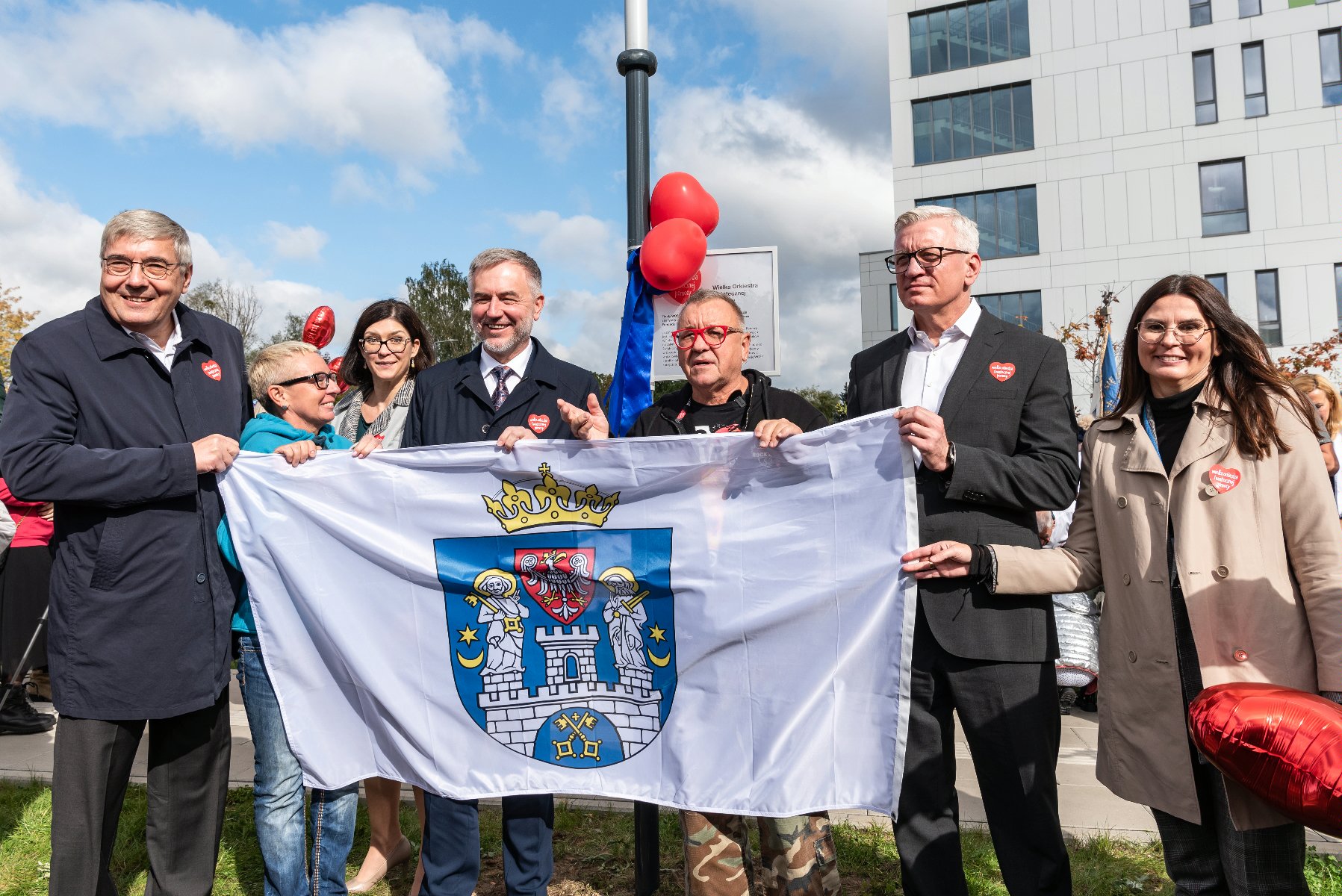 Na zdjęciu samorządowcy oraz Jurek Owsiak, wszyscy trzymają flagę Poznania - grafika artykułu