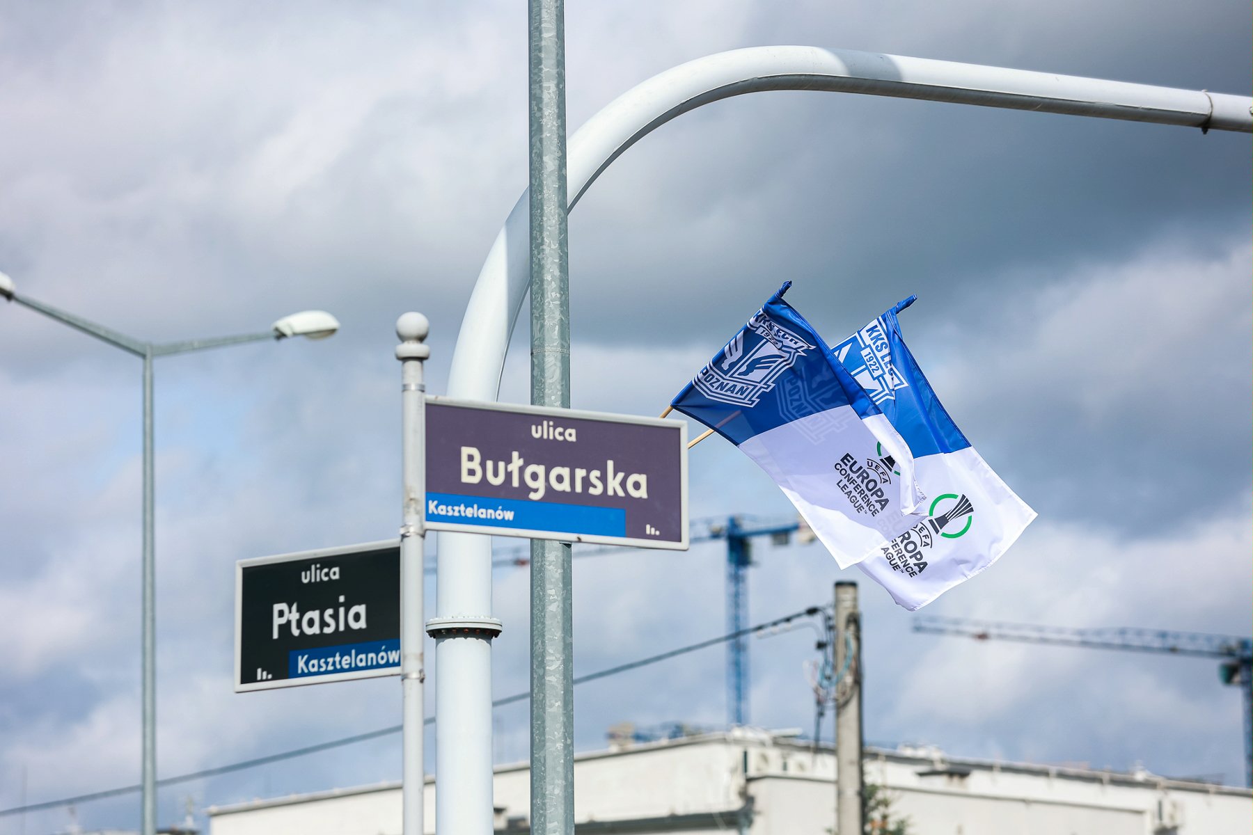 Niebiesko-białe flagi Lecha Poznań wiszące przy ulicach wokół stadionu miejskiego w Poznaniu - grafika artykułu