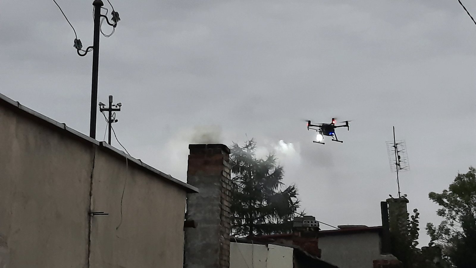 Na zdjęciu dron nad budynkiem, z komina unosi się dym