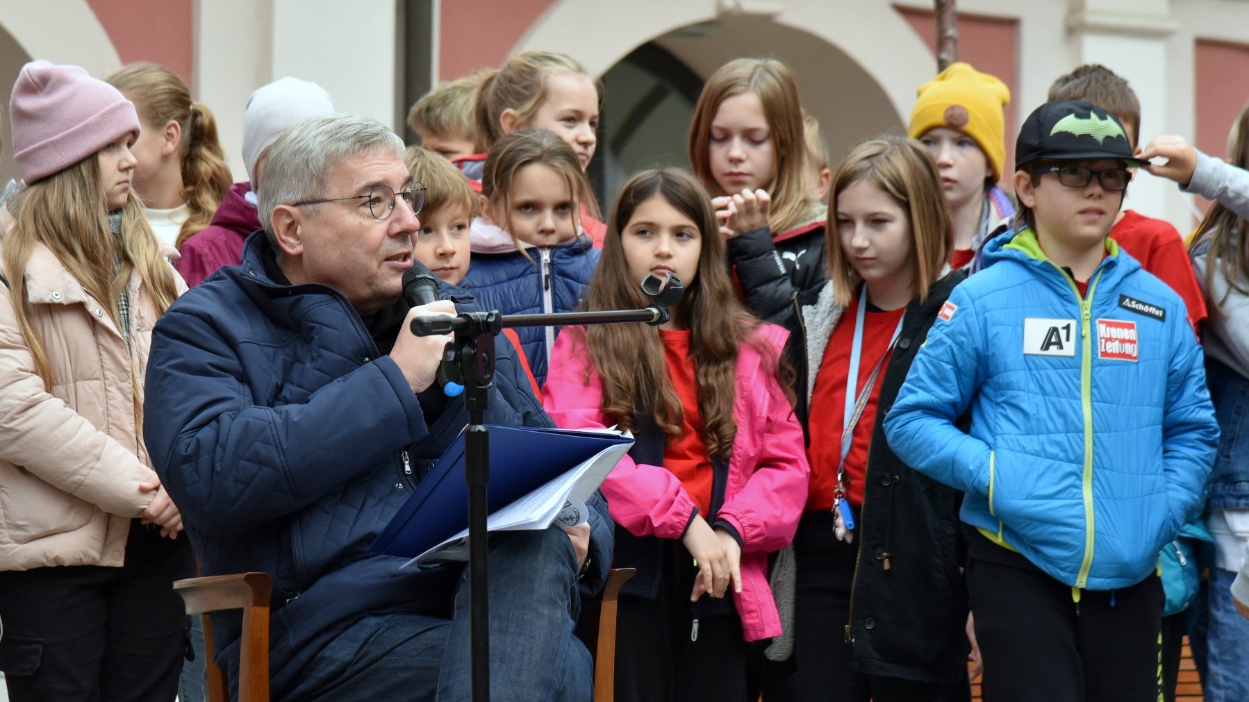 Na zdjęciu Grzegorz Ganowicz, czytający dzieciom, za nim zebrani uczniowie