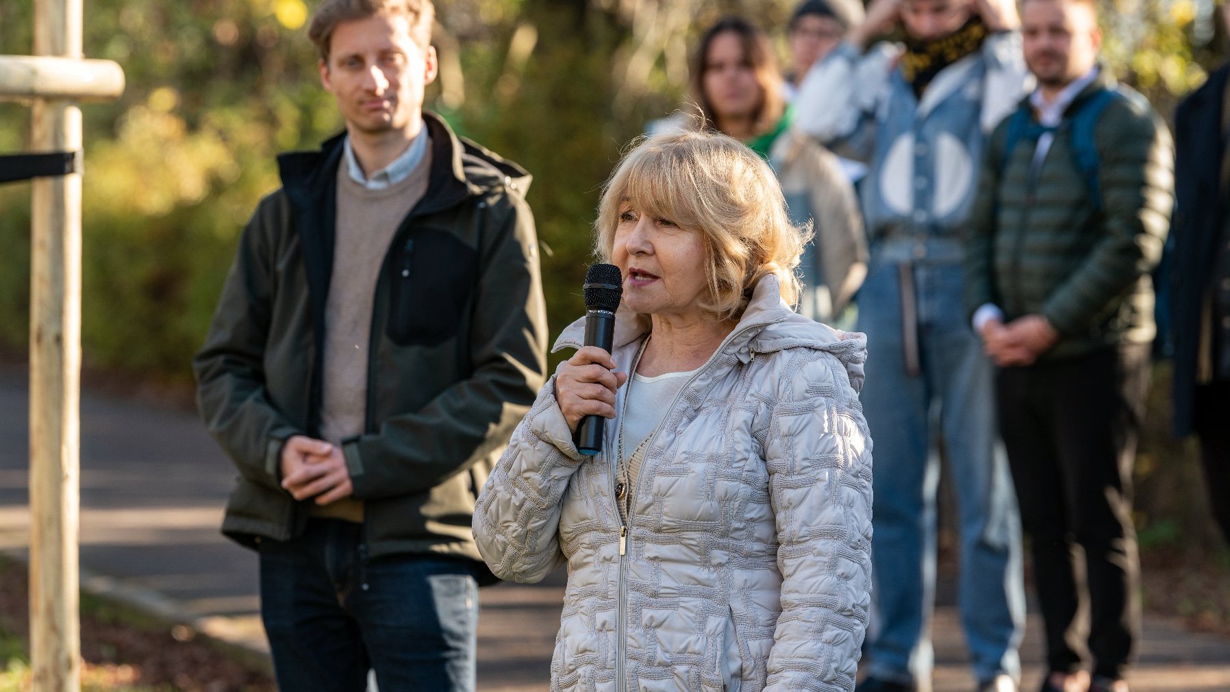 Na zdjęciu dyrektorka szkoły z mikrofonem, za nią grupa ludzi