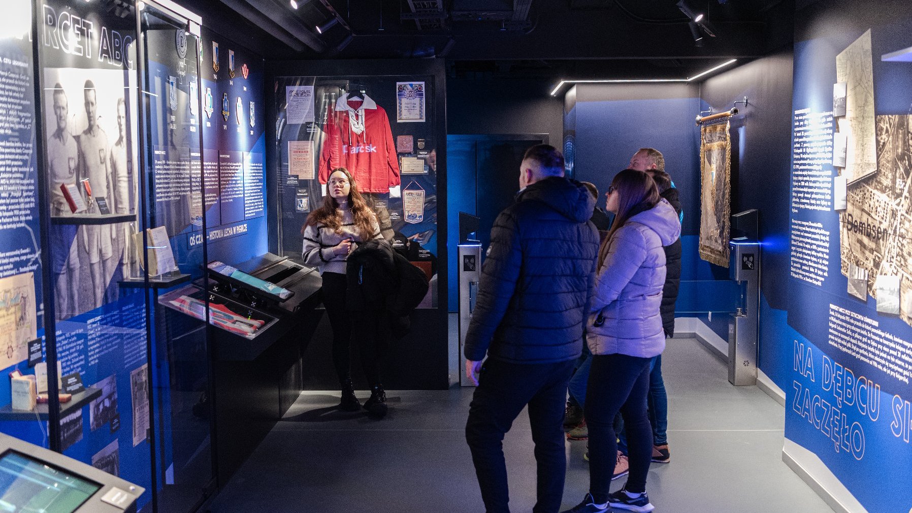 Na zdjęciu grupa osób w muzeum, patrzących na ekspozycję