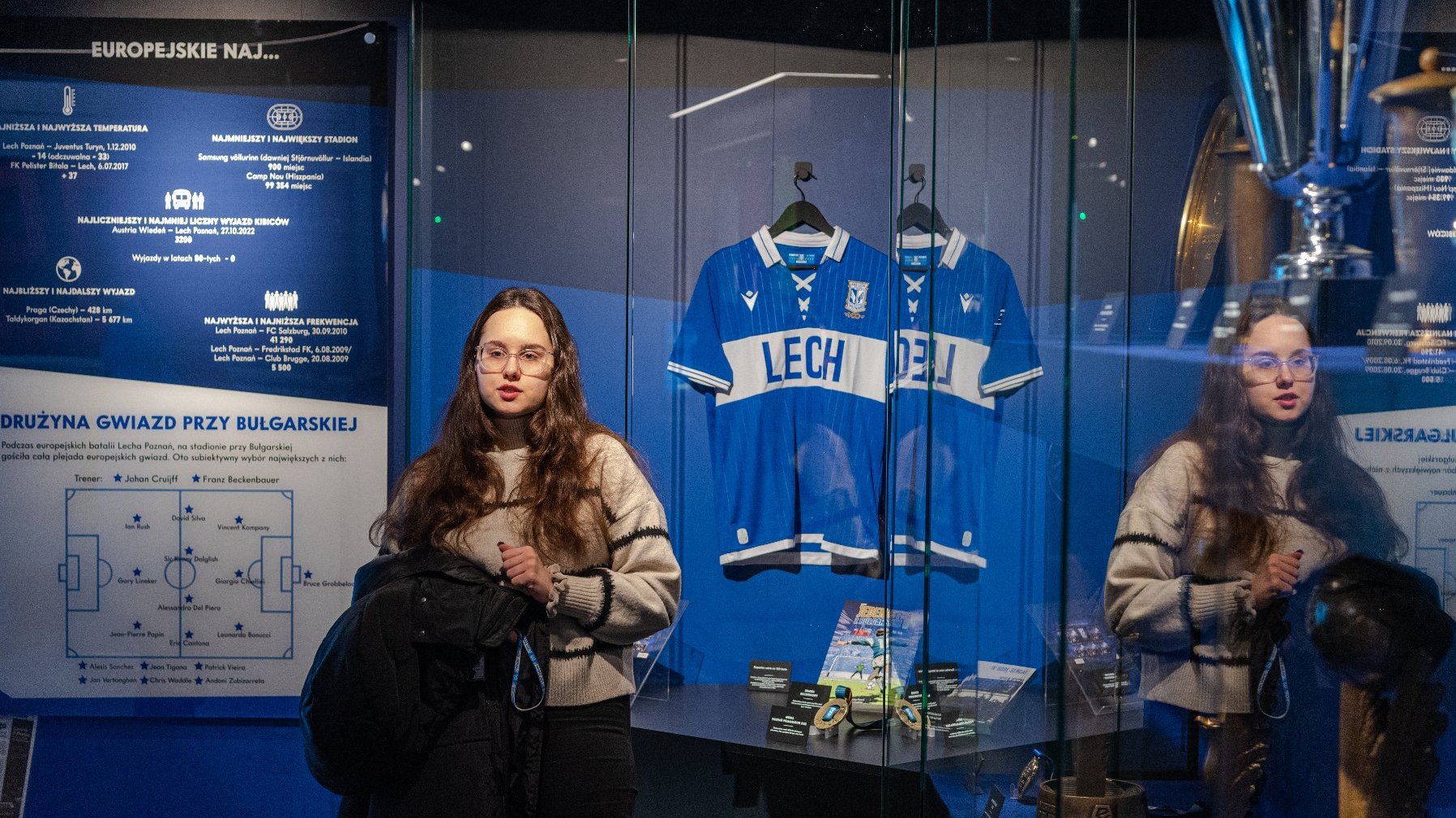 Na zdjęciu kobieta stojąca obok ekspozycji muzeum