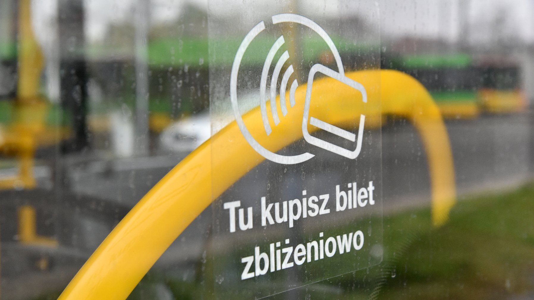 Naklejka na drzwiach autobusu informująca o płatności zbliżeniowych