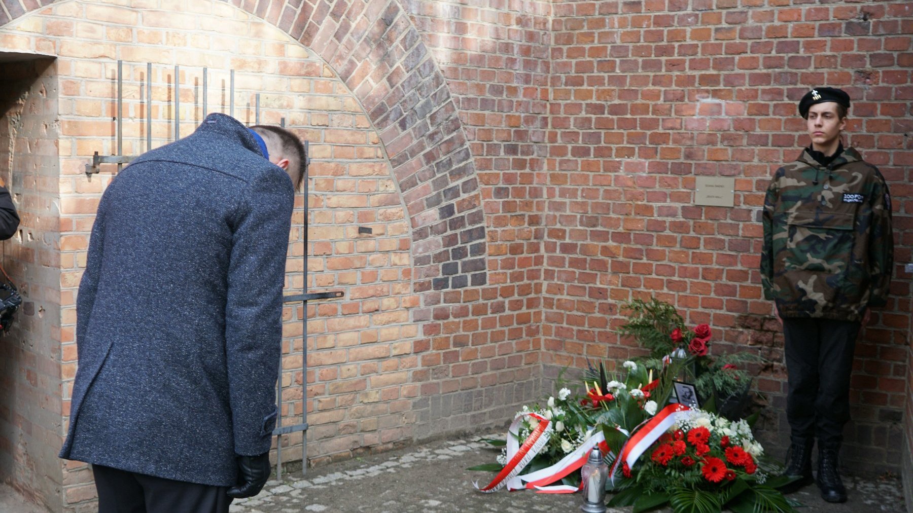 Na zdjęciu zastępca prezydenta Poznania, w pokłonie przed tablicą pamiątkową