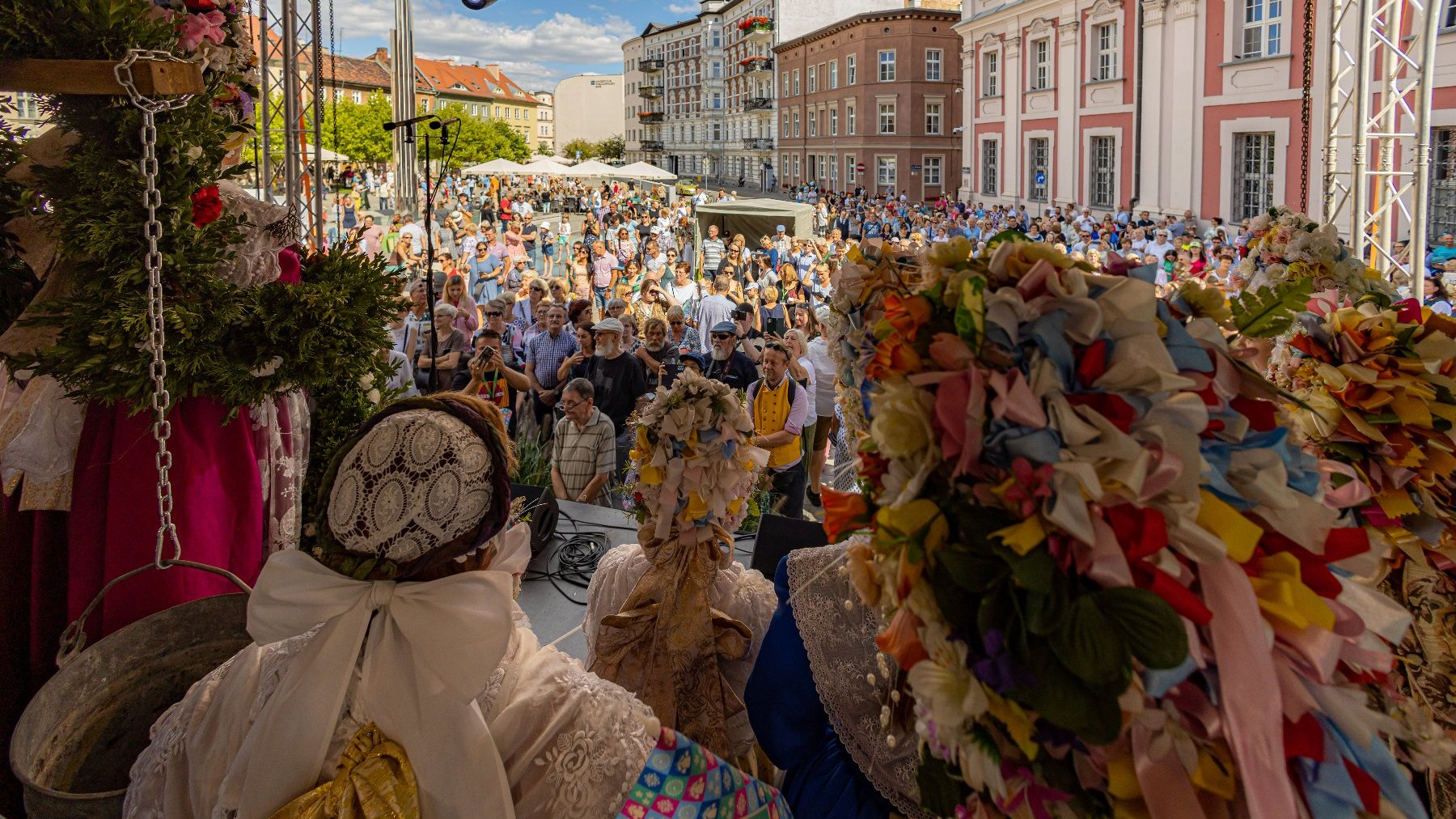 Na zdjeciu tłum ludzi na placu Kolegiackim, na pierwszym planie osoby w tradycyjnych strojach Bambrów