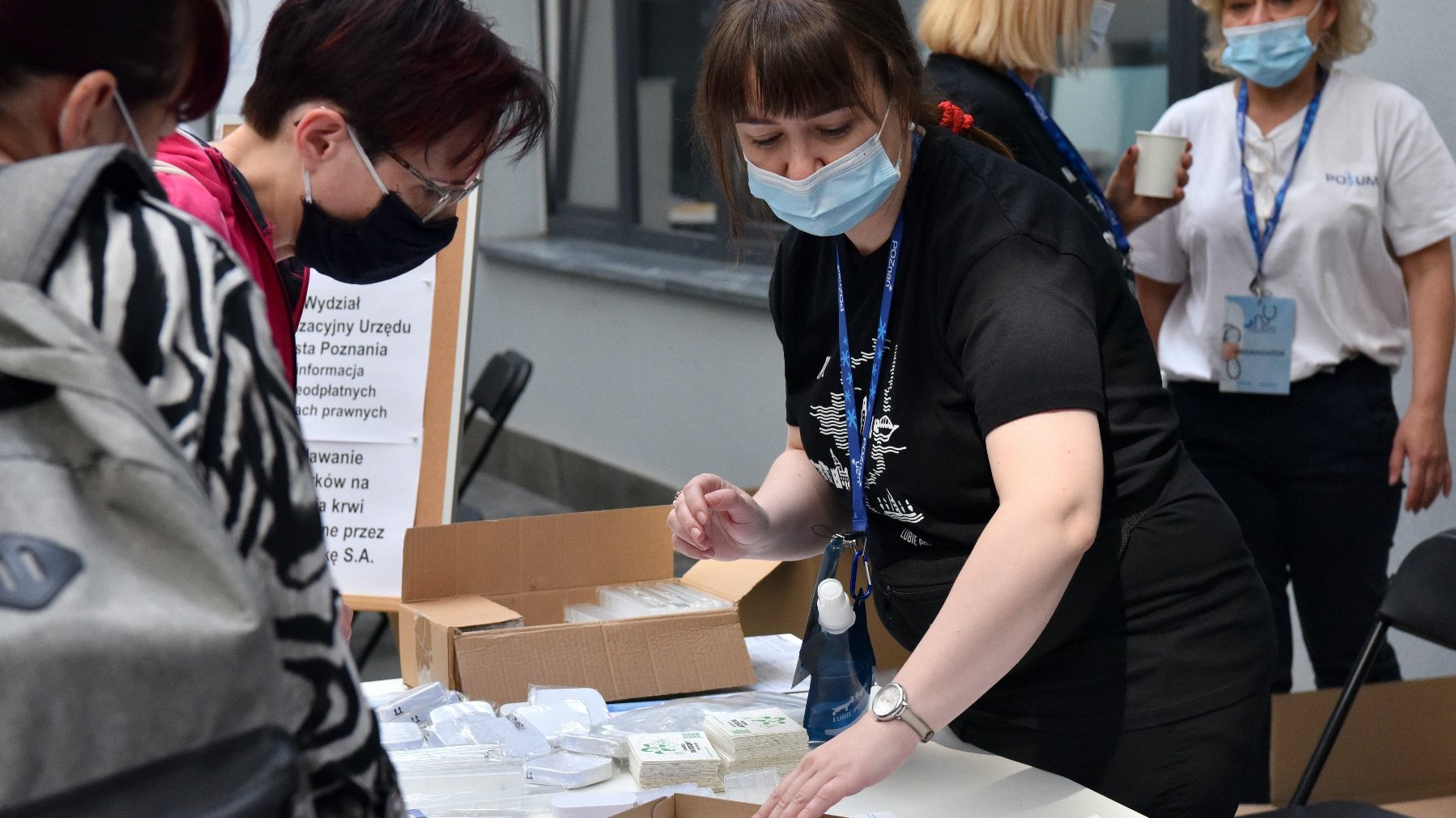 Na zdjęciu kobieta prezentująca materiały edukacyjne wyłożone na stoliku