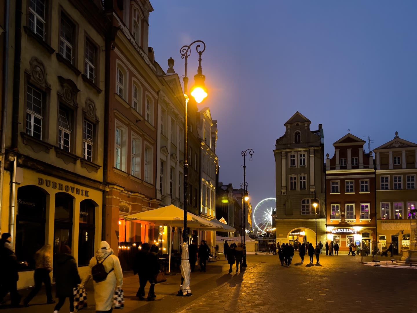 Stary Rynek w nowym oświetleniem i ludźmi chodzącymi po nowej nawierzchni - grafika artykułu