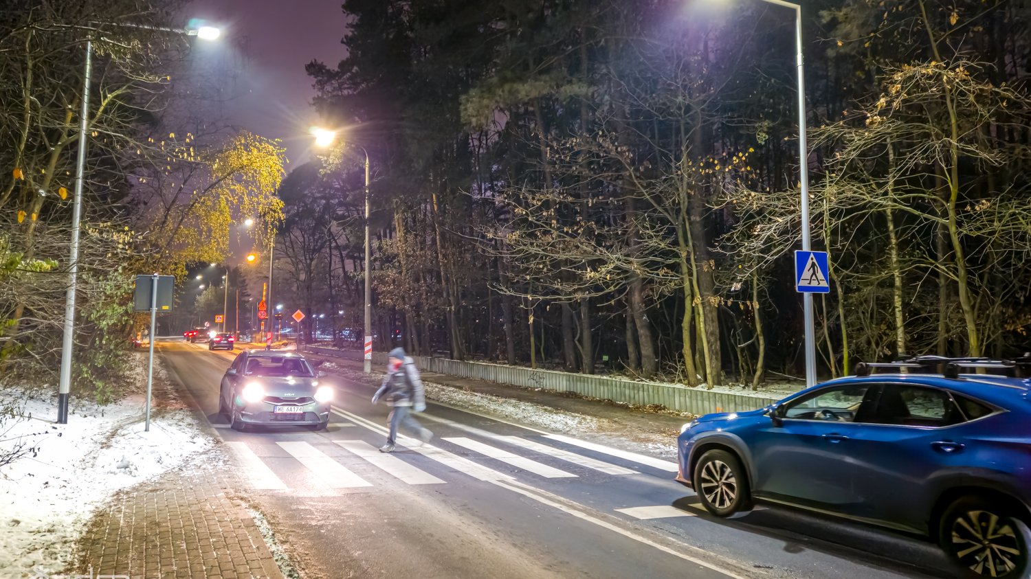 Galeria zdjęć przedstawia oświetlone przejście dla pieszych.