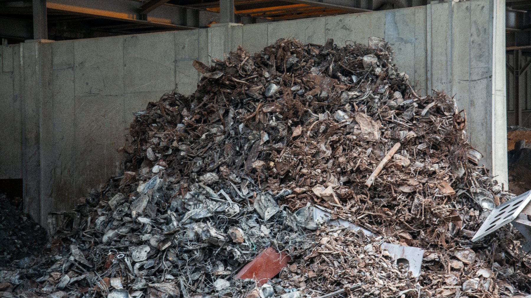 Na zdjęciu dużo odpadów składowanych pod ścianą