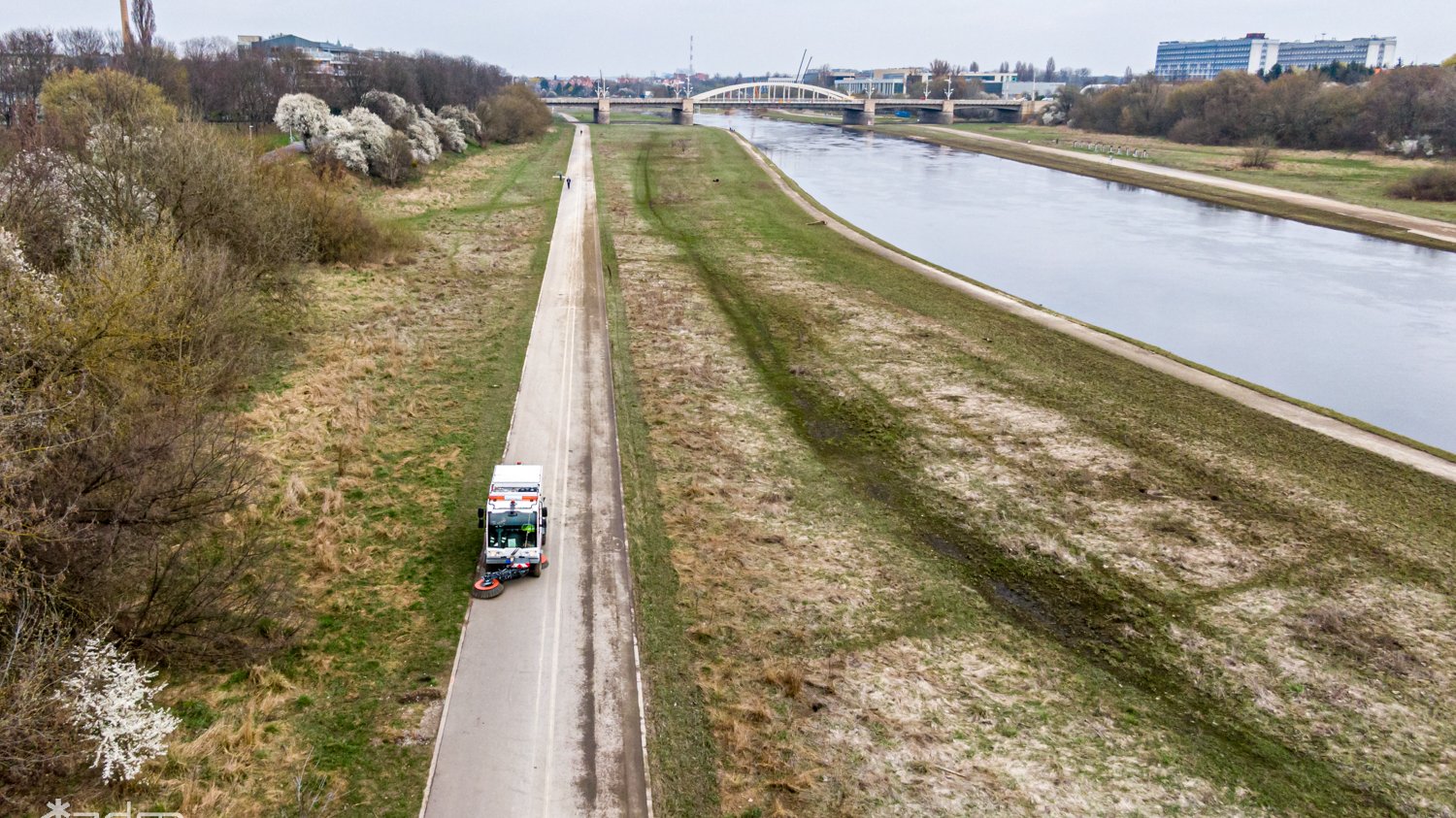 Zdjęcie przedstawia samochód sprzątający na Wartostradzie z lotu ptaka.