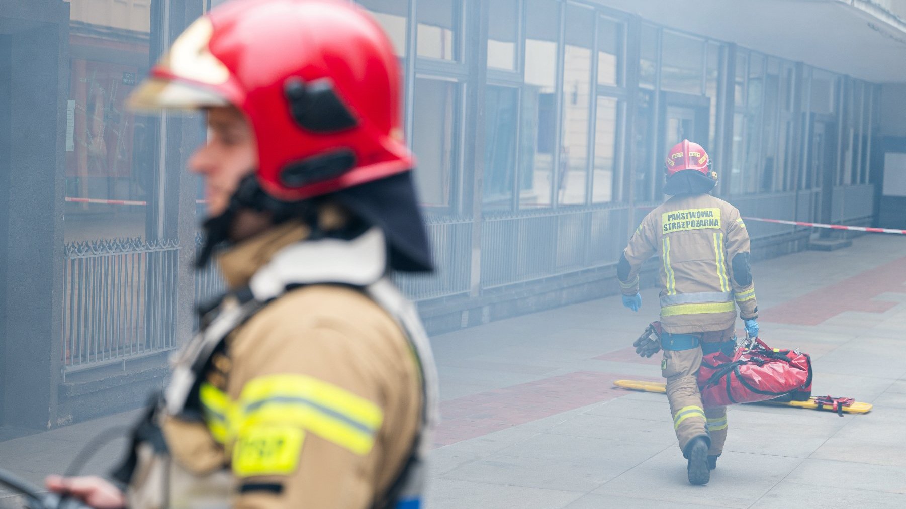Na zdjęciu dwóch strażaków, w tle zadymiona przestrzeń na Starym Rynku