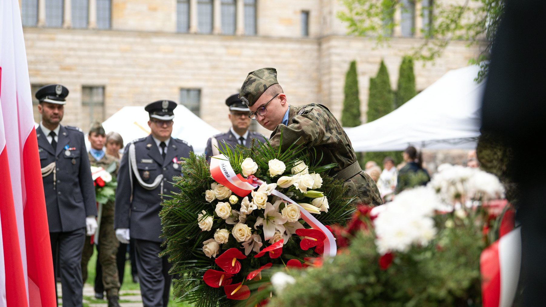 Na zdjęciu żołnierz składający kwiaty