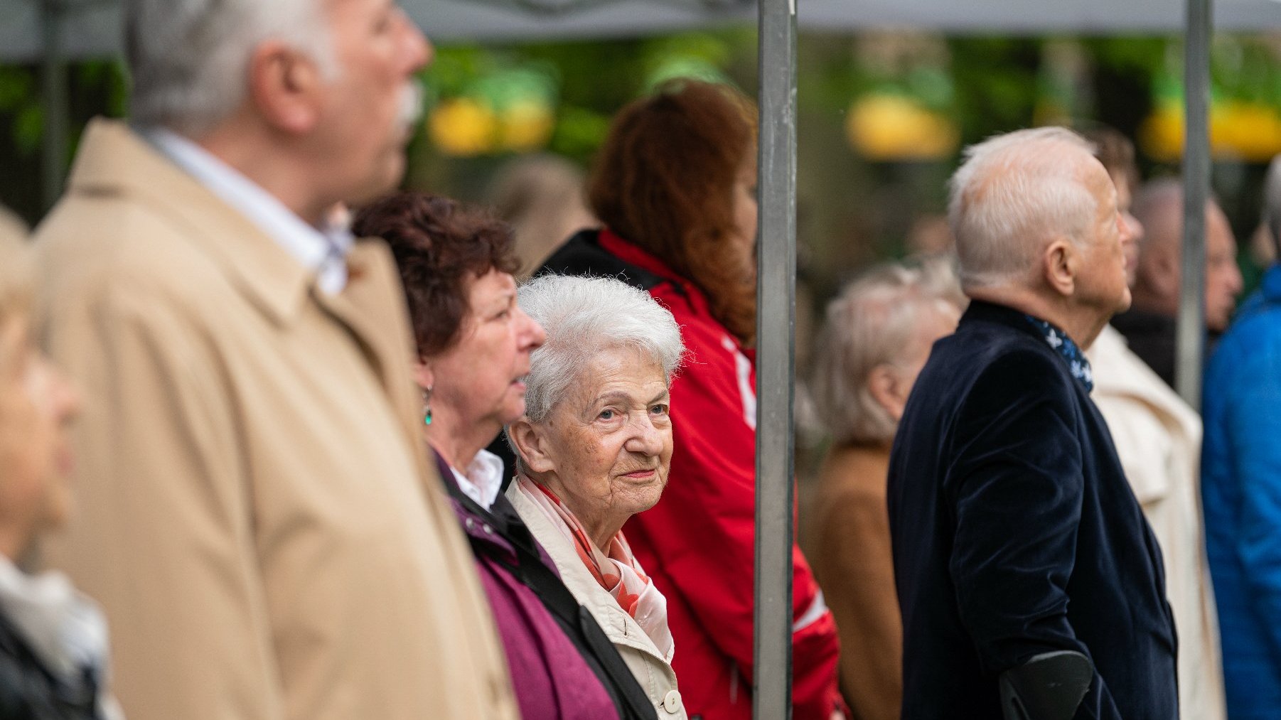 Na zdjęciu uczestnicy uroczystości, w centrum starsza kobieta o siwych włosach