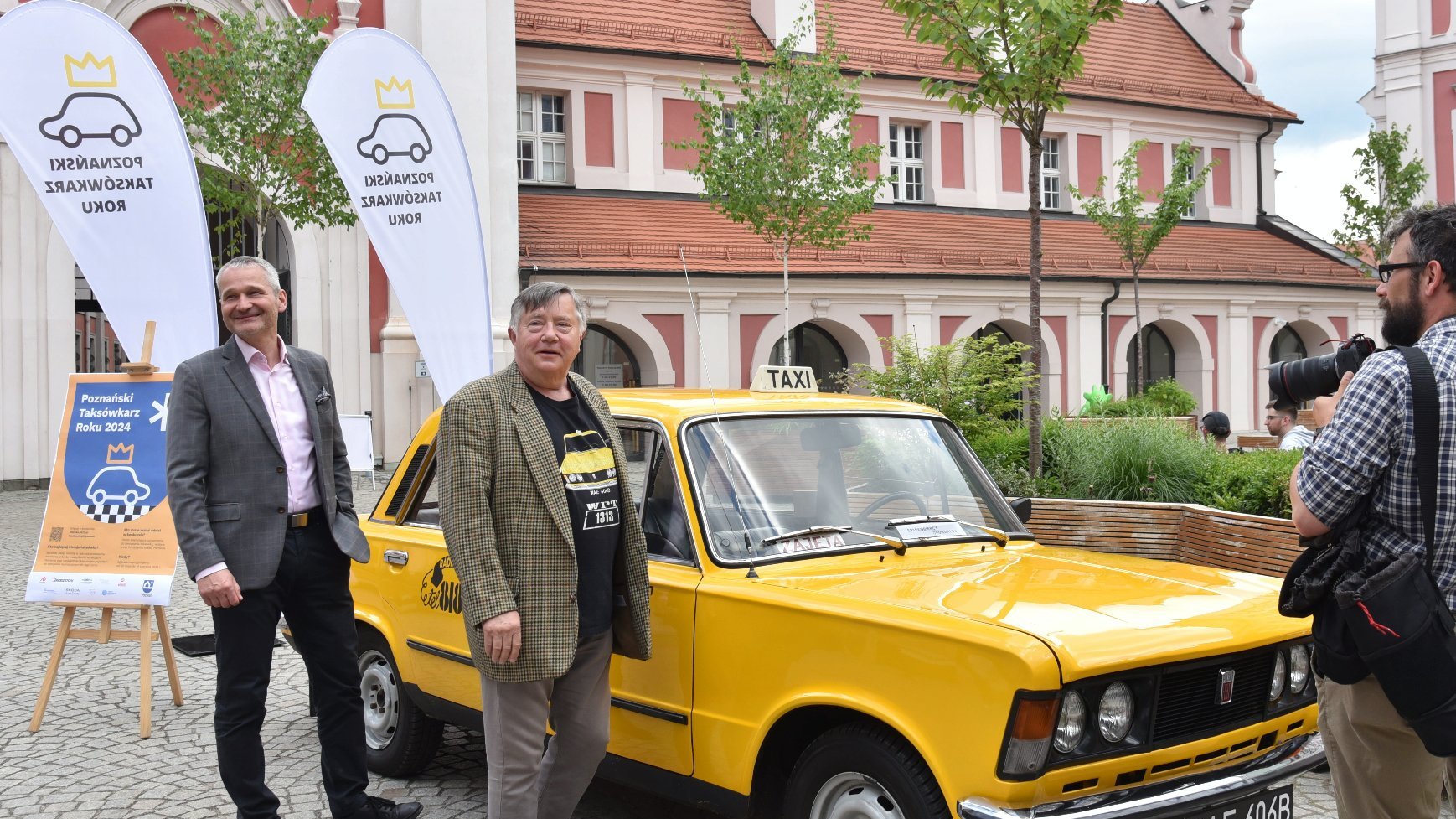 Zdjęcie przedstawia wiceprezydenta Solarskiego i Mieczysława Hryniewicza przed żółtą taksówką.
