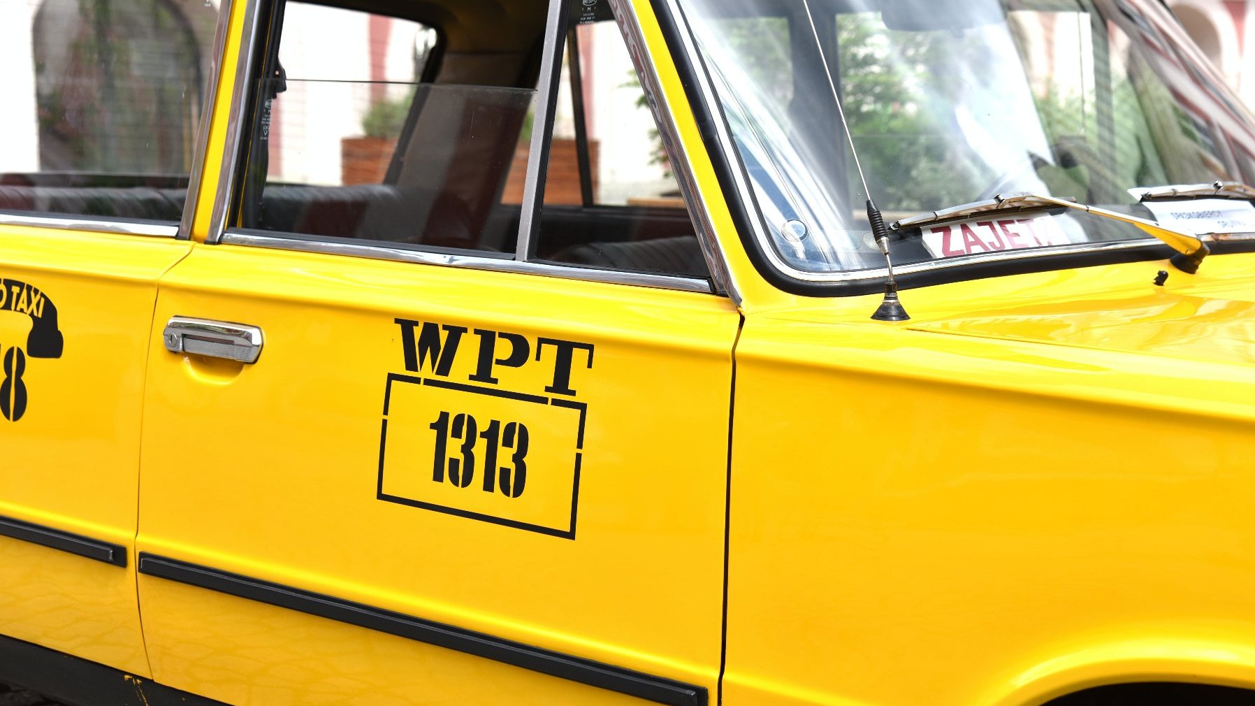 Zdjęcie przedstawia numer boczny żółtej taksówki.