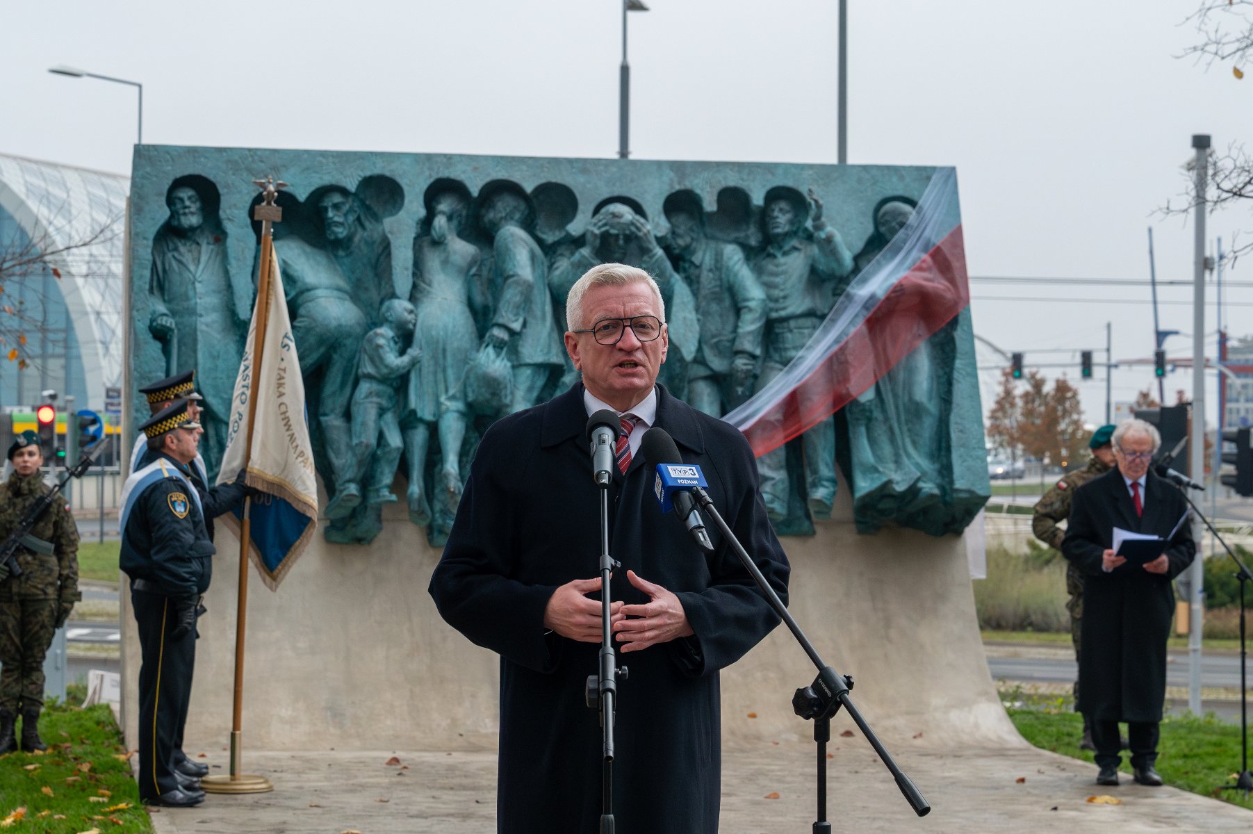 Na zdjęciu prezydent Poznania przy mikrofonie, w tle pomnik - grafika artykułu