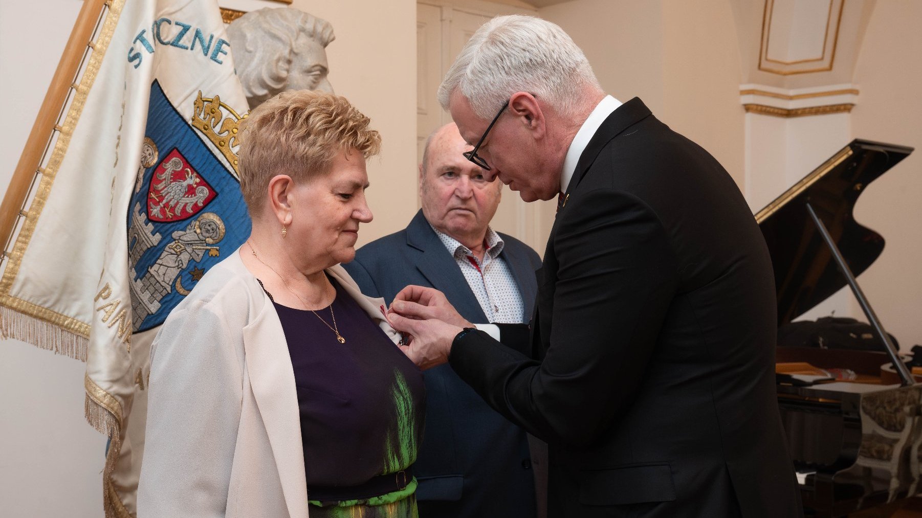 Na zdjęciu prezydent Poznania przypinający medal kobiecie