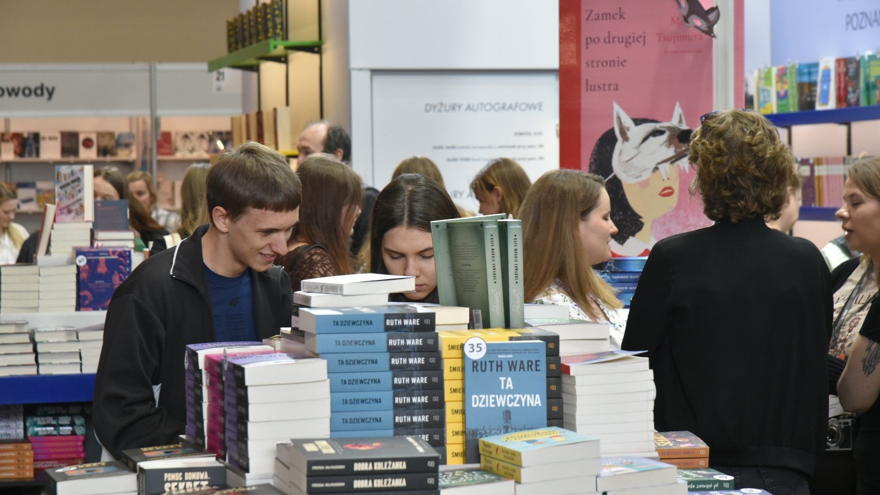 Na zdjęciu ludzie przeglądający książki