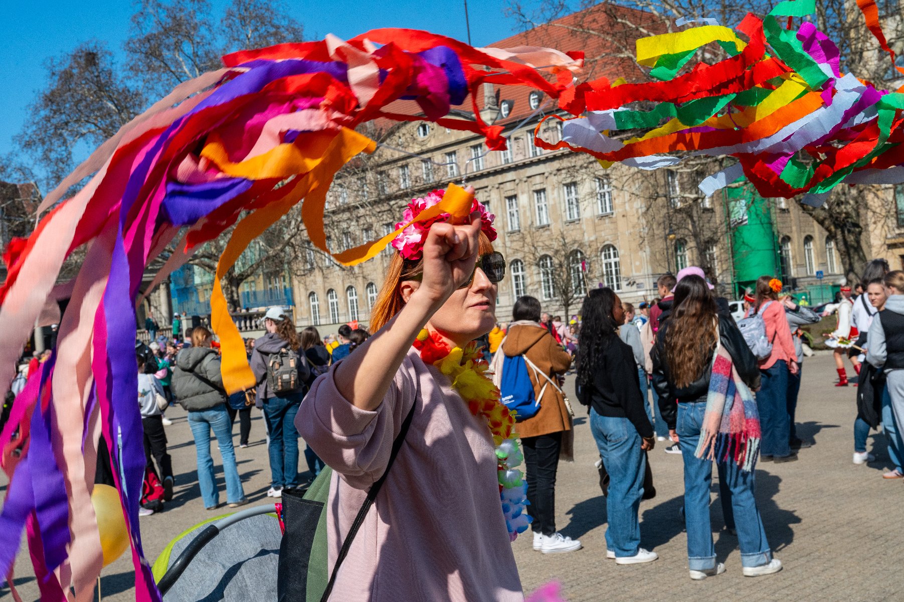 Na zdjeciu kobieta w wianku, machająca kolorową wstęgą - grafika artykułu