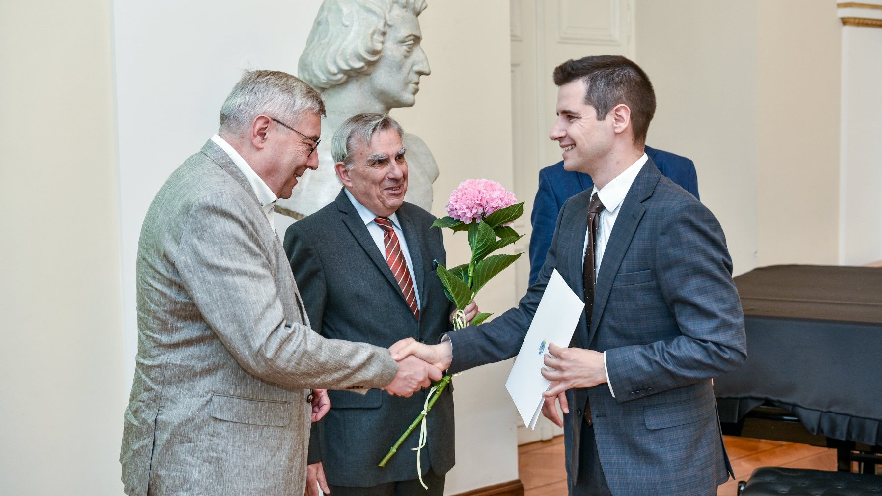 zdjęcie przedstawia moment wręczenia stypendium jednemu z laureatów